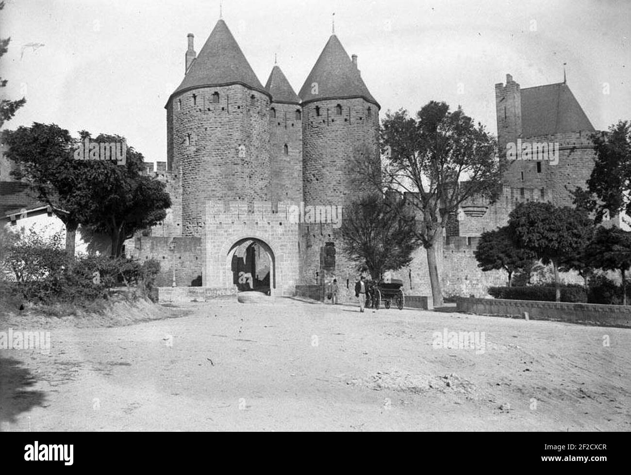 Portal, torres i muralla de la ciutat de Carcassona i un carro amb un Home (beschnitten). Stockfoto