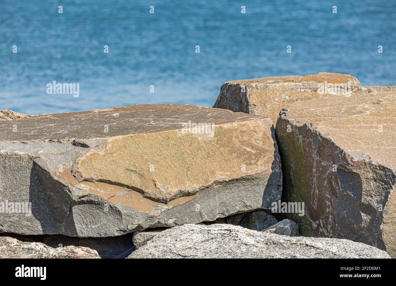 Detail Gruppe von großen Felsbrocken und Wasser dahinter Stockfoto