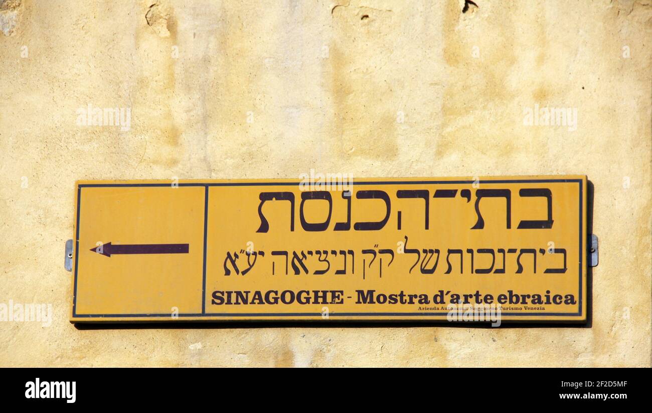 Straßenschild in hebräischer und italienischer Sprache an der Wand des venezianischen Ghettos, das auf die Synagoge und die Ausstellung jüdischer Kunst, Venedig, Italien, zeigt Stockfoto
