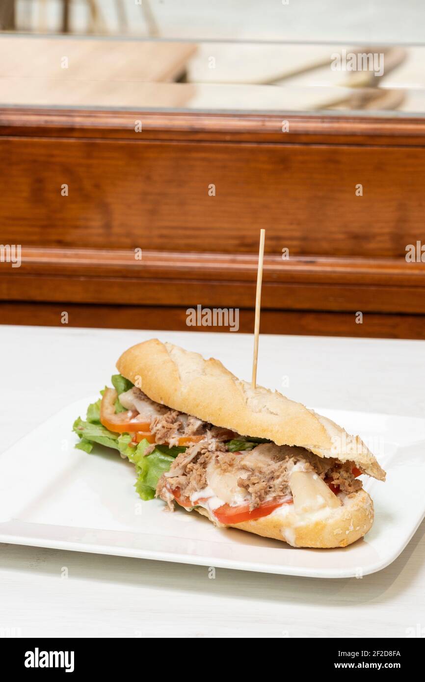 Thunfischsalat mit Mayo-Baguette auf einer weißen Tischdecke Ein Restaurant Stockfoto