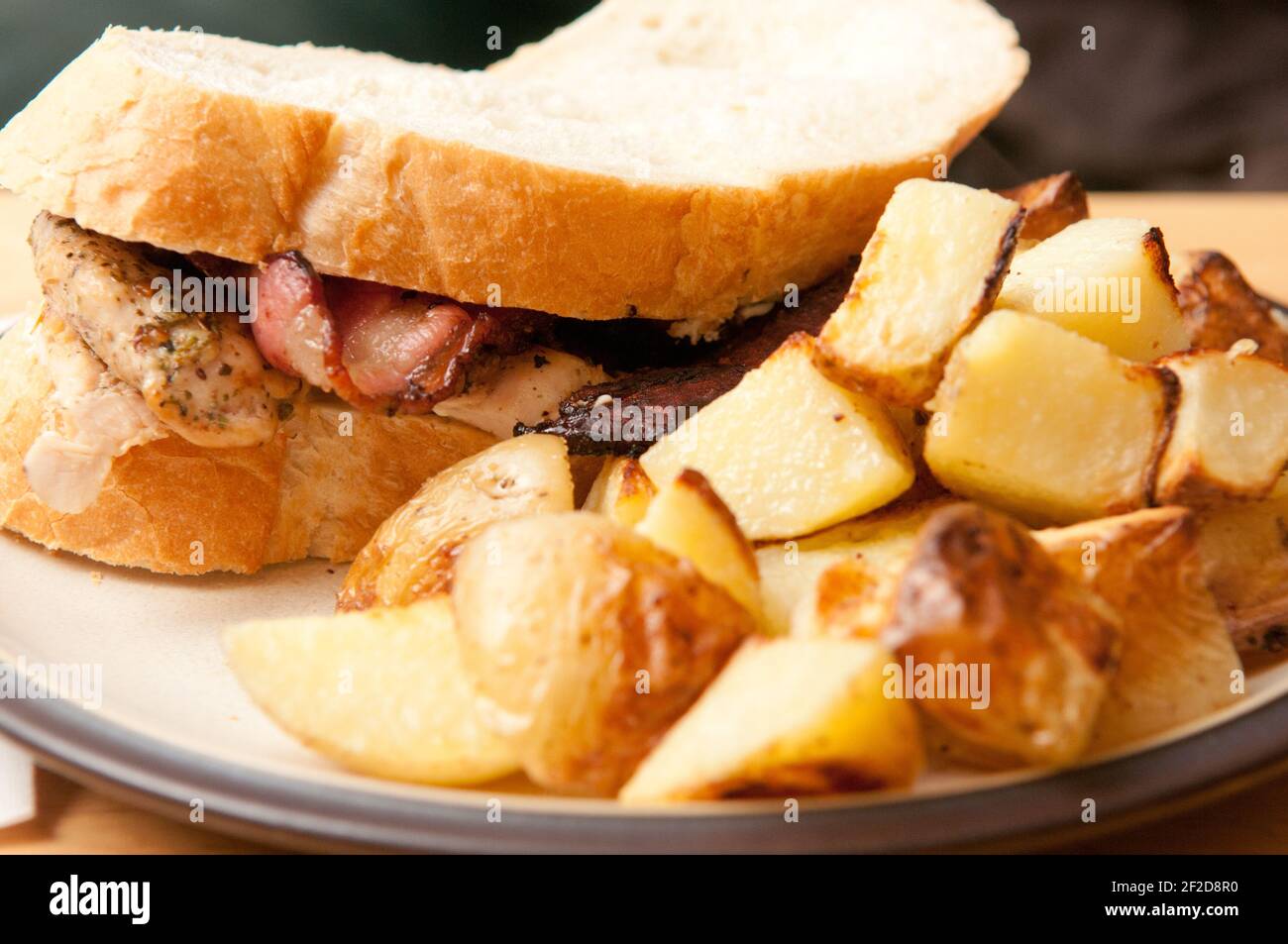 Ein leckeres Fleisch-Sandwich mit gebratenen Kartoffeln serviert Stockfoto