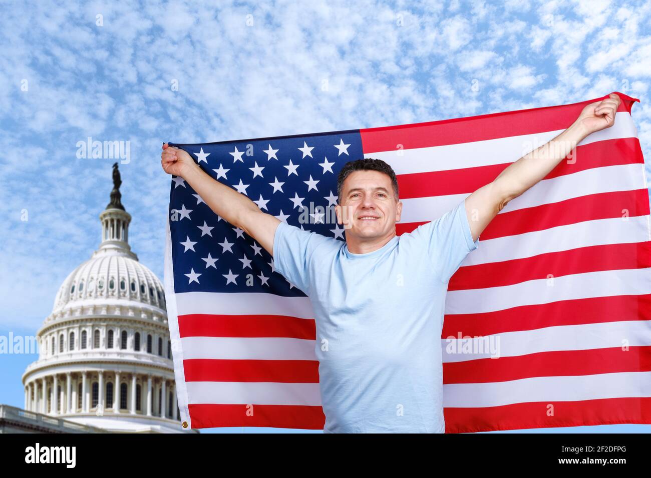 Der Mann hält die amerikanische Flagge in ausgestreckten Armen Stockfoto