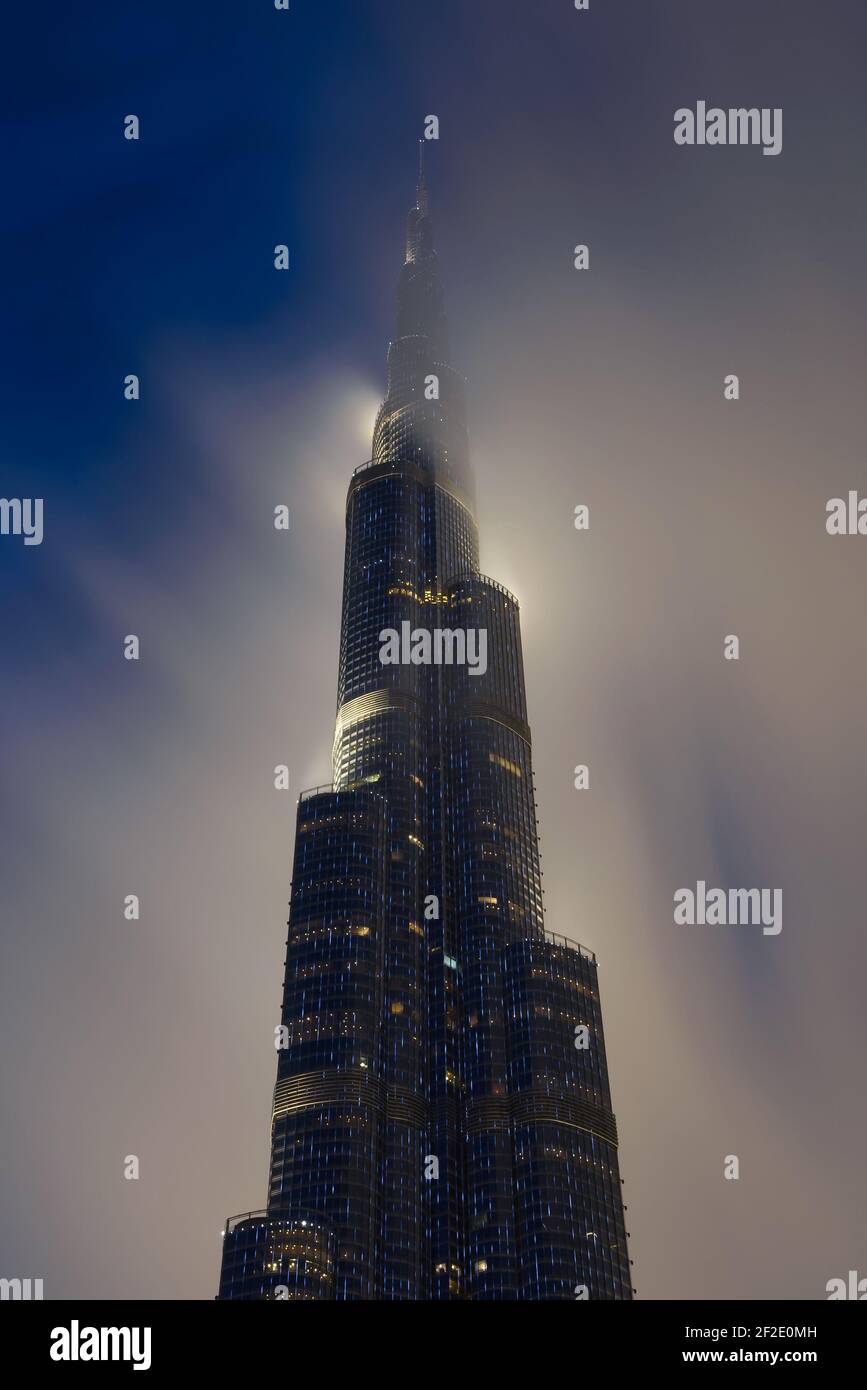 Burj Khalifa Gebäude in der Nacht mit der Spitze von niedrigen Wolke bedeckt. Wolkenkratzer in Dubai, Vereinigte Arabische Emirate. Hochhaus oben hinter Wolken. Stockfoto