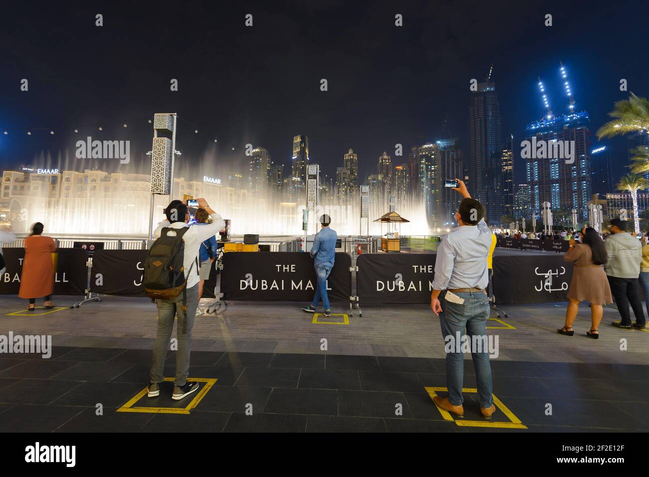 Die Dubai Fountain Show mit Grundzeichen für soziale Distanzierung für Touristen, die während einer Pandemie reisen. Touristenattraktion während der COVID-19 in Dubai. Stockfoto