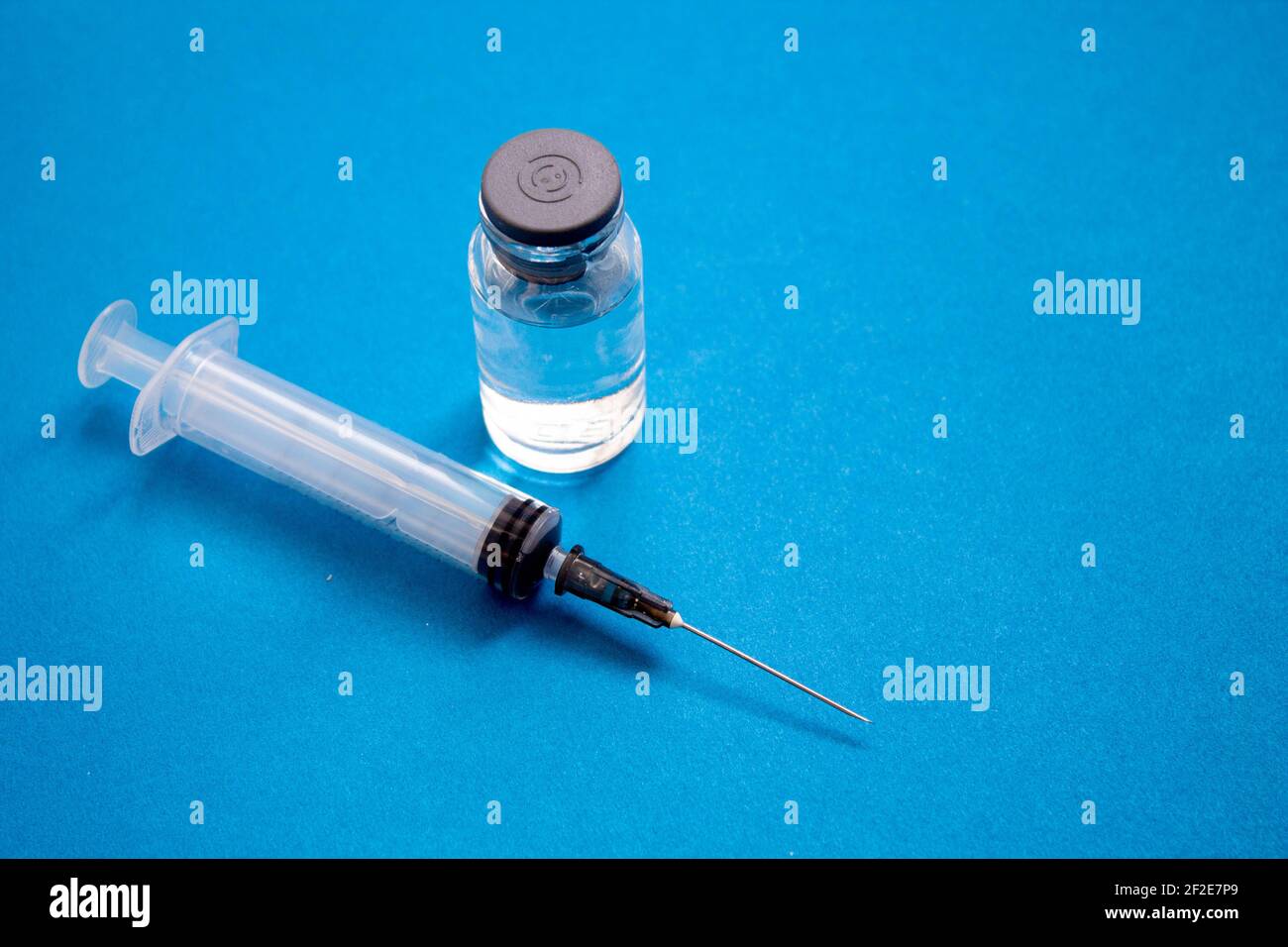 Gegenmittel und Spritze. Impfstoff für Tiere in einer Ampulle auf blauem Hintergrund. Stockfoto