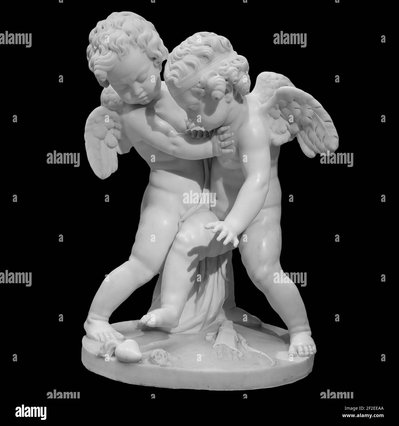 Zwei schwarze Engelsfiguren isoliert auf weißem Hintergrund. Cupids Skulptur. Steinstatue von jungen Cherubs Stockfoto