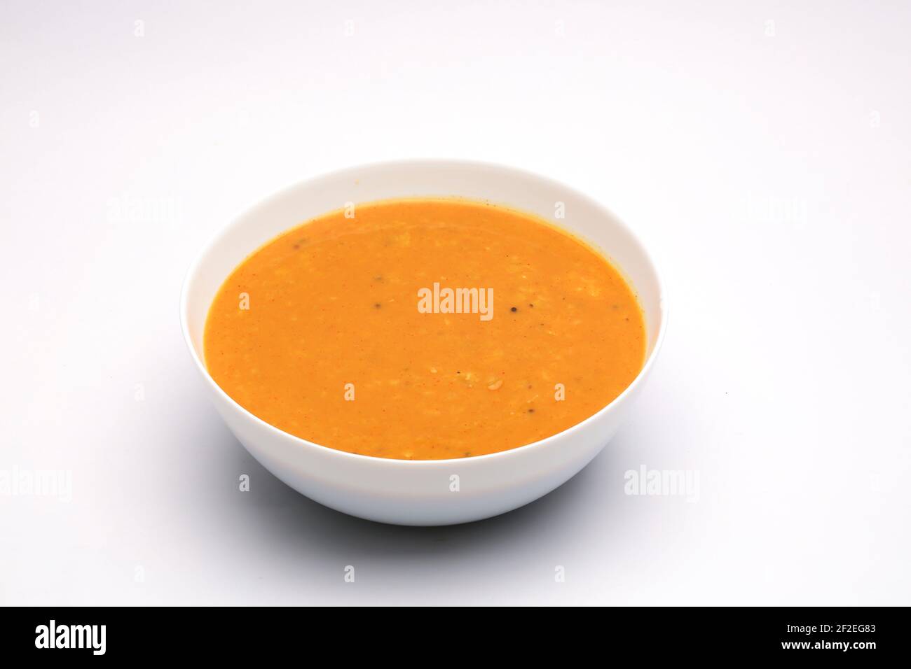 Veg Curry oder Dal Curry, gelbes Curry das Hauptgericht der Indianer und gute Kombination für Chappati und Mahlzeiten in einer weißen Schüssel auf weißer Textur angeordnet Stockfoto