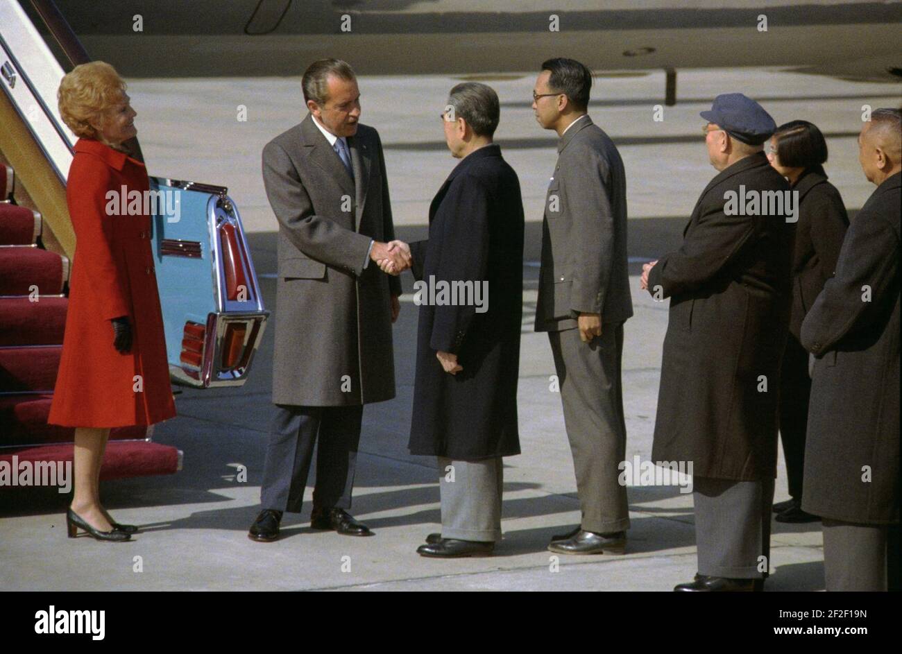 Präsident Richard Nixon und Premier Chou en-Lai schütteln die Hände bei der Ankunft der Nixons in Peking, China. Stockfoto