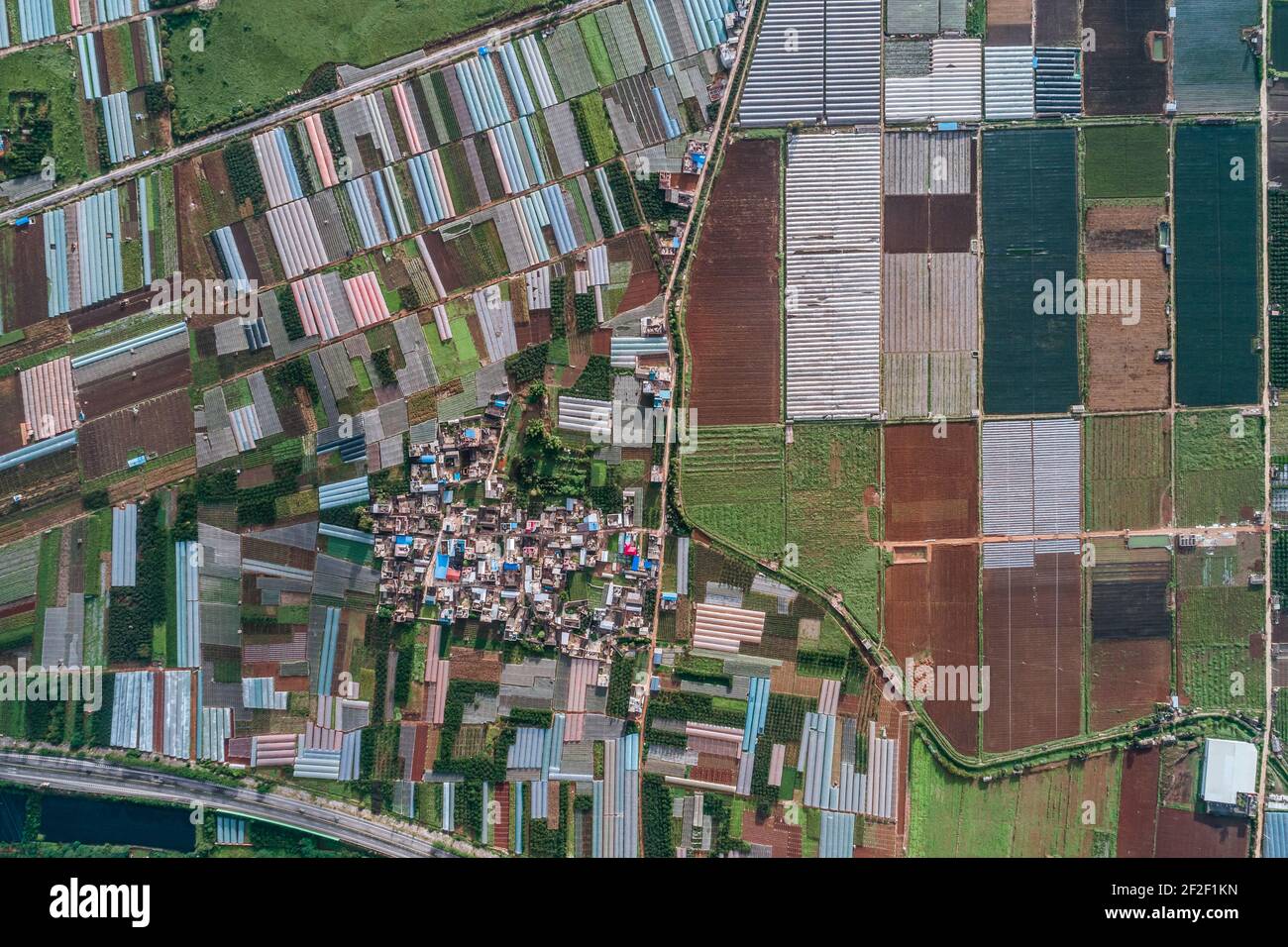 Luftaufnahme von landwirtschaftlichen Grundstücken unter Anbau in einer landwirtschaftlichen Stadt. Mengzi, Provinz Yunnan, China Stockfoto