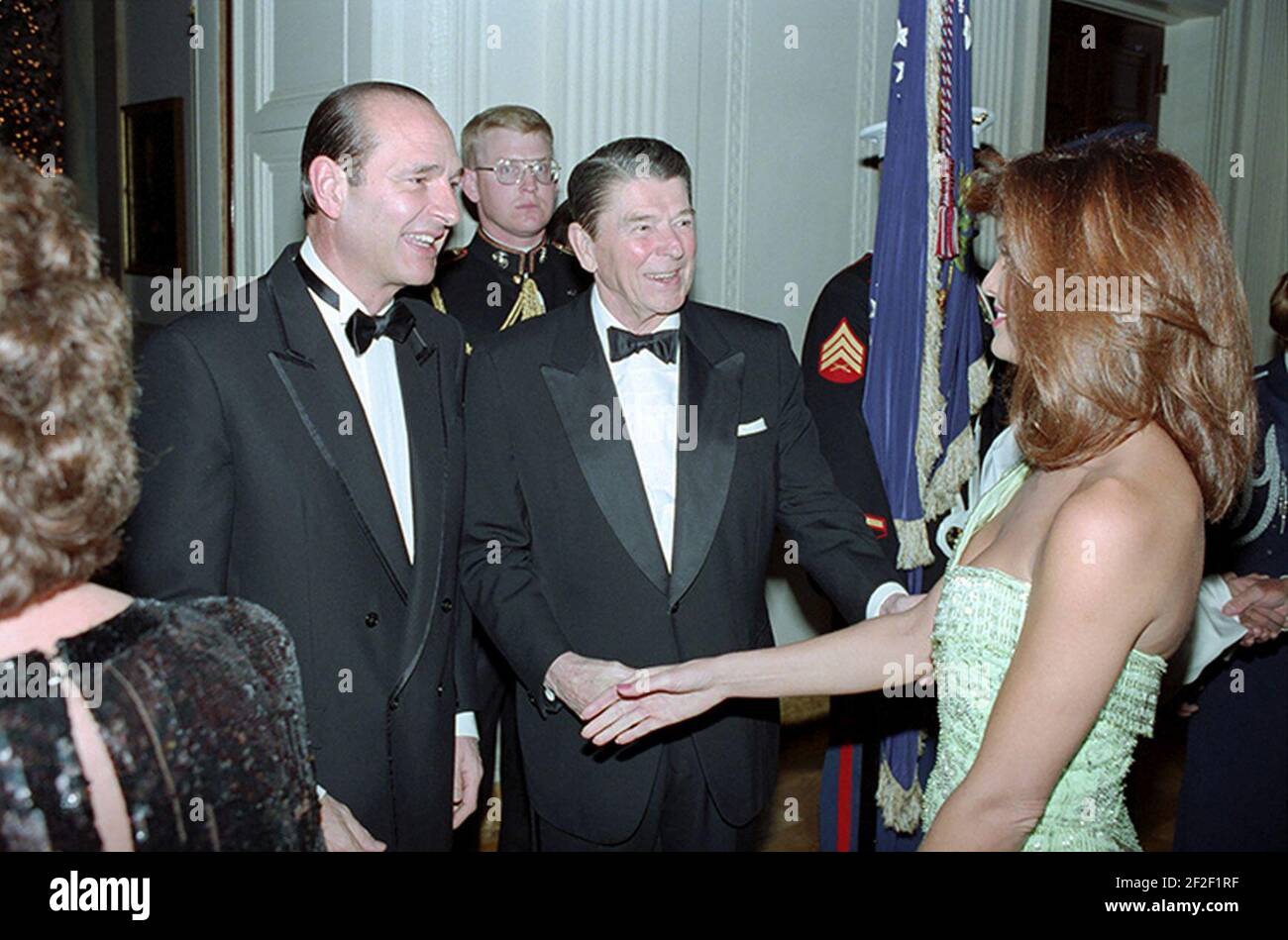 Präsident Ronald Reagan und Jacques Chirac begrüßen die Schauspielerin Tracy Scoggins. Stockfoto