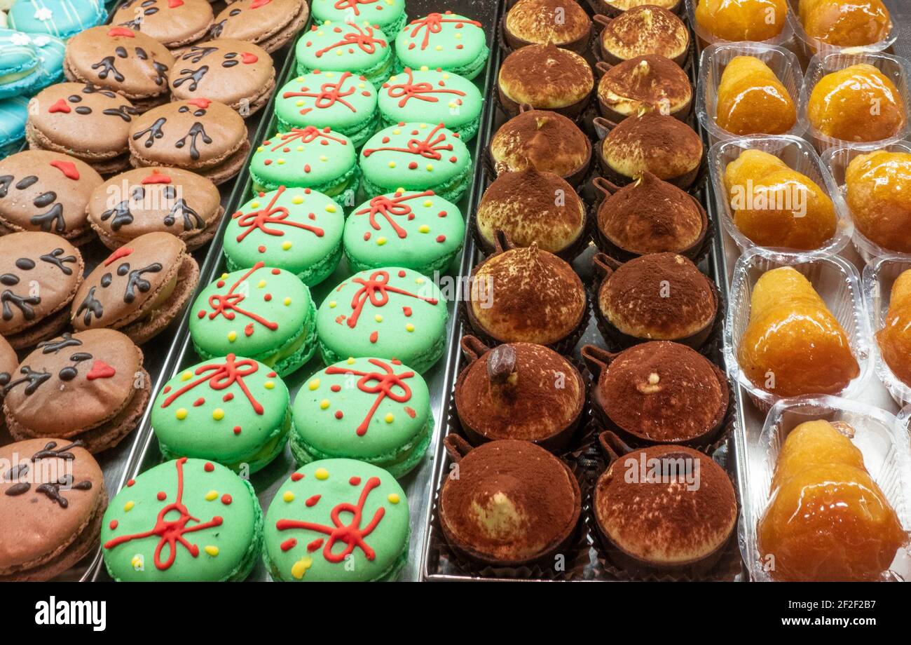 Bunte Macarons und leckeres Gebäck im Fenster der Konditorei Stockfoto