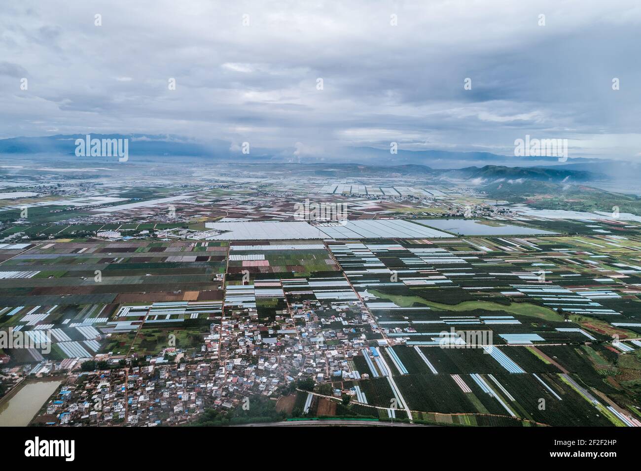 Luftaufnahme von landwirtschaftlichen Grundstücken unter Anbau in einer landwirtschaftlichen Stadt. Mengzi, Provinz Yunnan, China Stockfoto