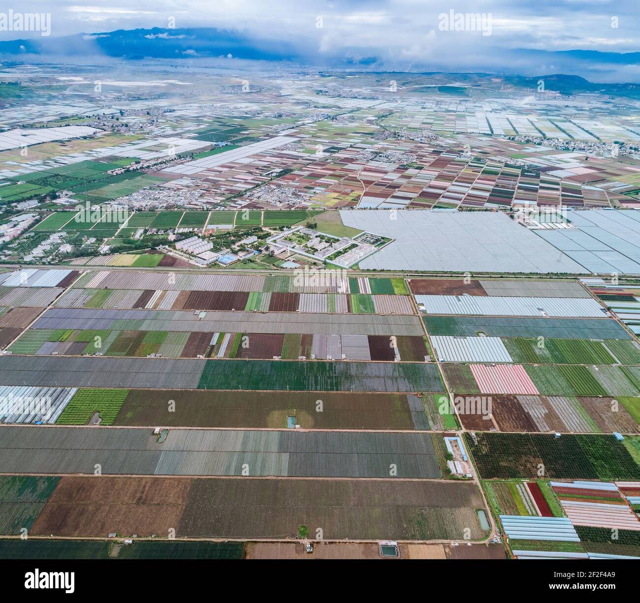 Luftaufnahme von landwirtschaftlichen Grundstücken unter Anbau in einer landwirtschaftlichen Stadt. Mengzi, Provinz Yunnan, China Stockfoto