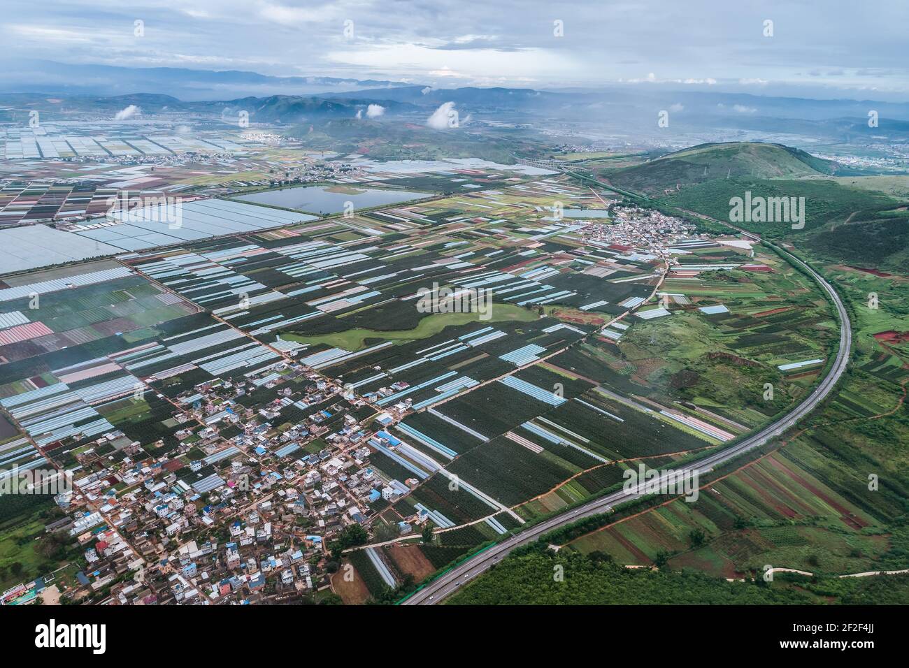 Luftaufnahme von landwirtschaftlichen Grundstücken unter Anbau in einer landwirtschaftlichen Stadt. Mengzi, Provinz Yunnan, China Stockfoto