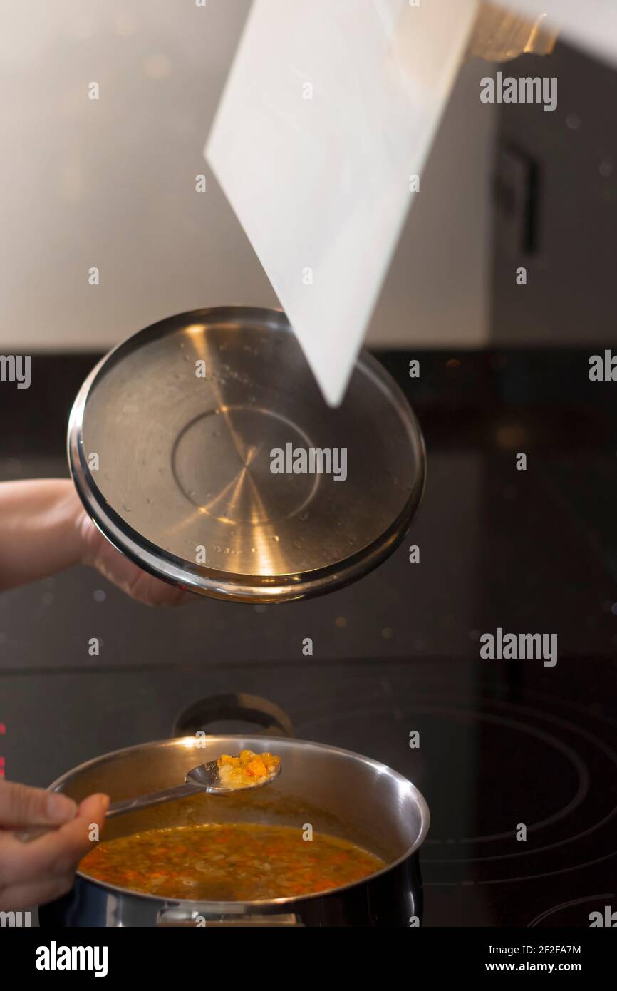 Echtes Foto des täglichen Lebens einer Frau, die köstliche Linsen zubereitete.um das Foto zu machen, wurde natürliches Licht verwendet und es wurde mit künstlichem l gefüllt Stockfoto