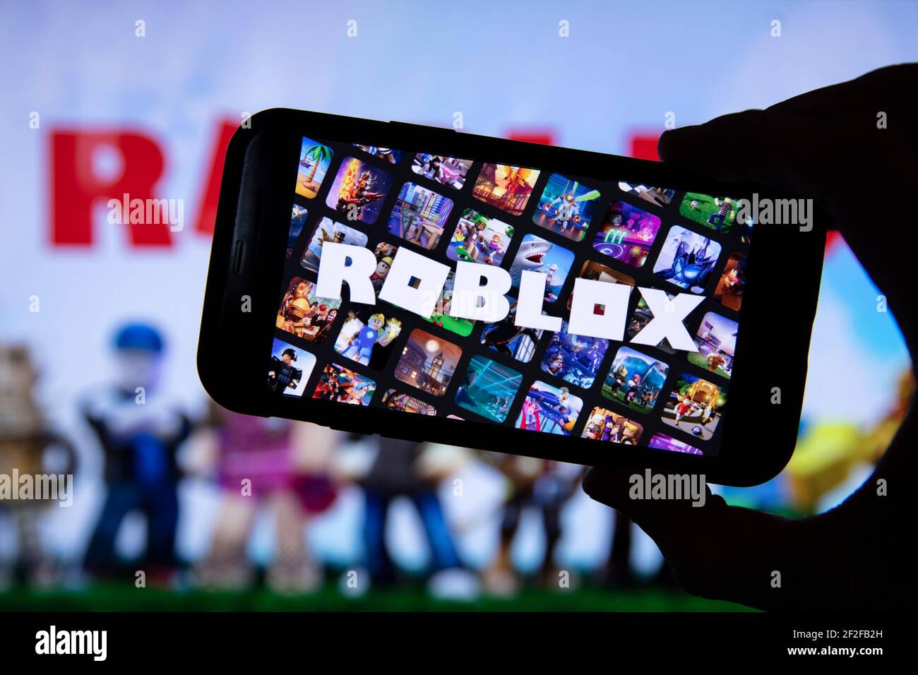 LONDON, UK - März 2021: Person mit einem Smartphone mit Roblox-Spiel-Logo Stockfoto