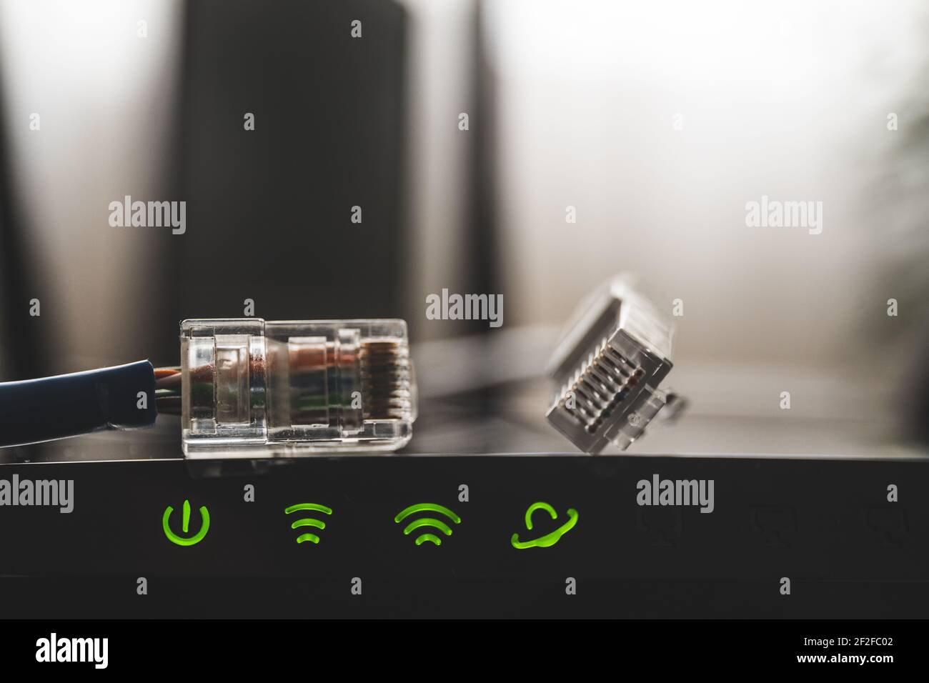 Nahaufnahme des Internet-Routers und grüne Symbole der WLAN-Verbindung. Internetkabel am Router Stockfoto