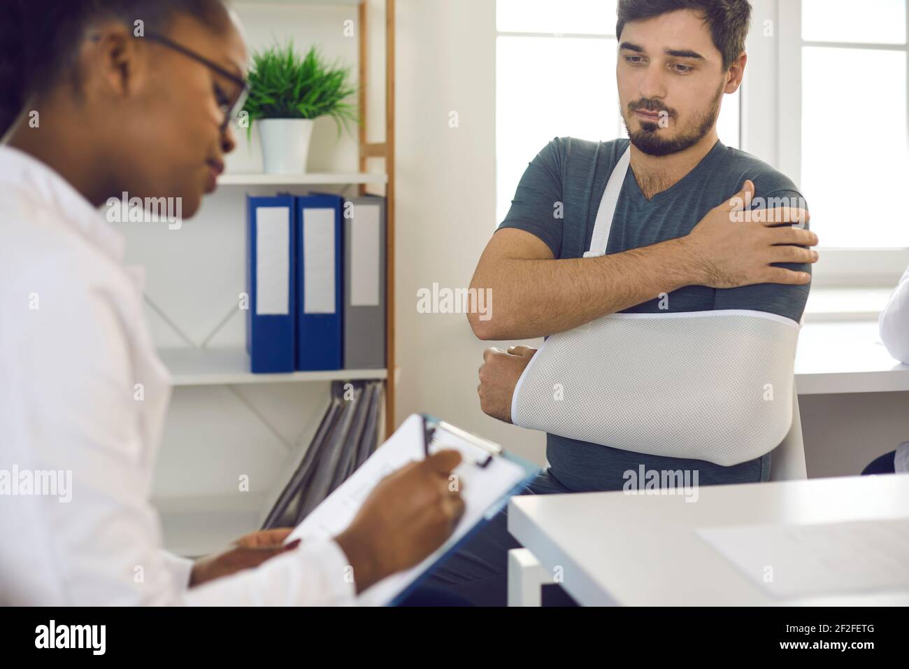 Arzt verschreibt Behandlung für junge Patienten mit gebrochener Hand, Handgelenk, Ellbogen oder Arm Stockfoto Arzt verschreibt Behandlung für junge Patienten mit gebrochener Hand, Handgelenk, Ellbogen oder Arm Stockfoto