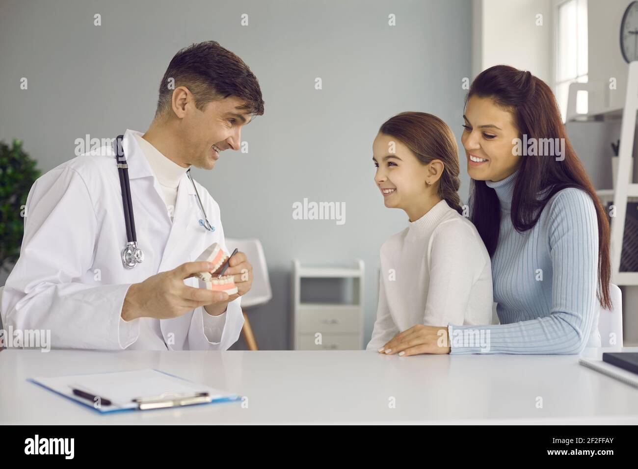 Pädiatrischer Zahnarzt oder Mundhygieniker lehrt kleines Kind zu reinigen Zähne richtig verzahnt Stockfoto