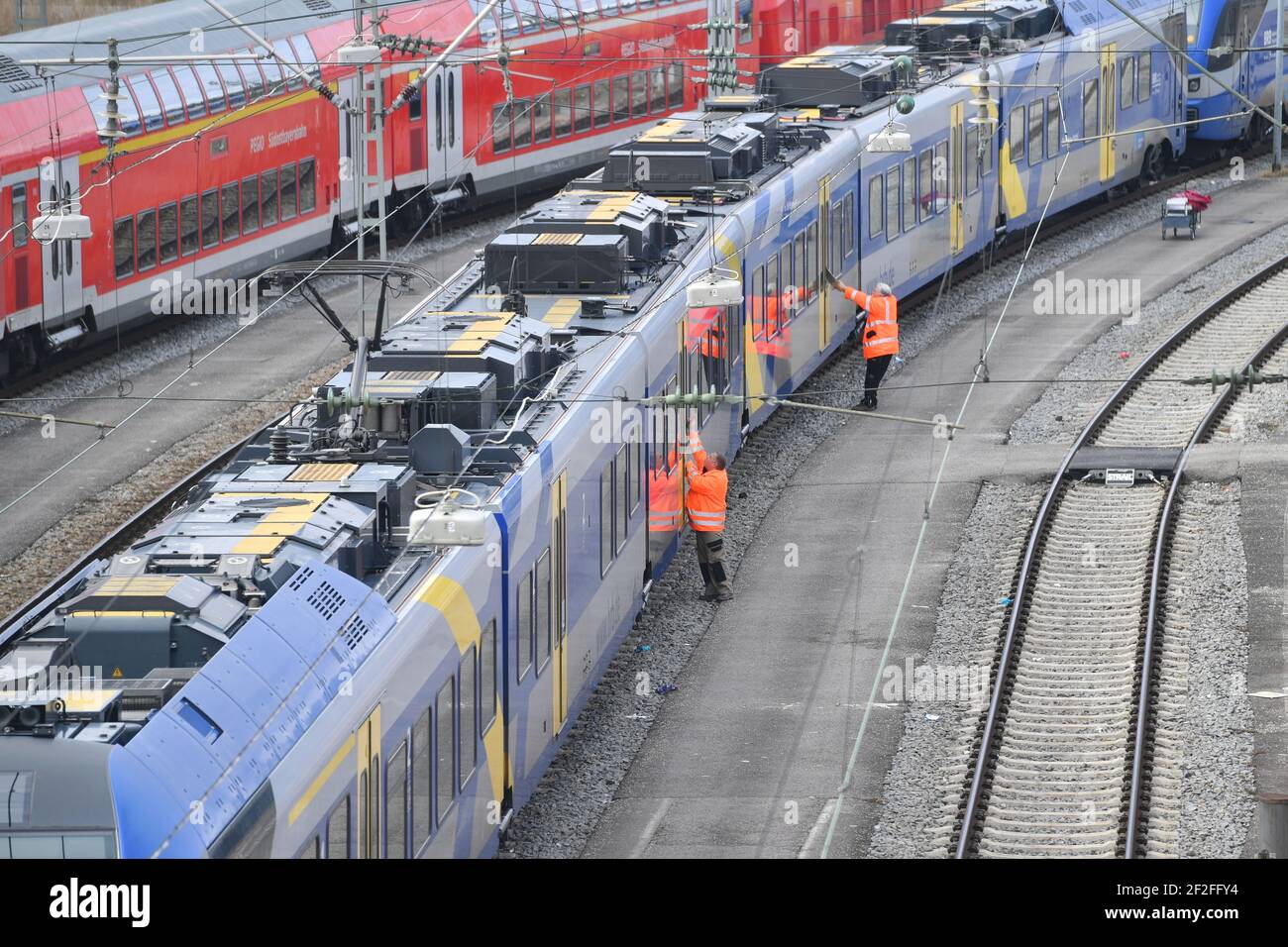 München, Deutschland. März 2021, 11th. Folgen der Coronavirus-Pandemie, geparkte Züge am Münchner Hauptbahnhof, Reinigungspersonal, Wartungspersonal reinigen am 11. März 2021 die Fenster, Fenster und Türen der DB, die Bahn, Stadt München. OEPNV, öffentlicher Verkehr, Fernverkehr, Schienenverkehr. Quelle: dpa/Alamy Live News Stockfoto