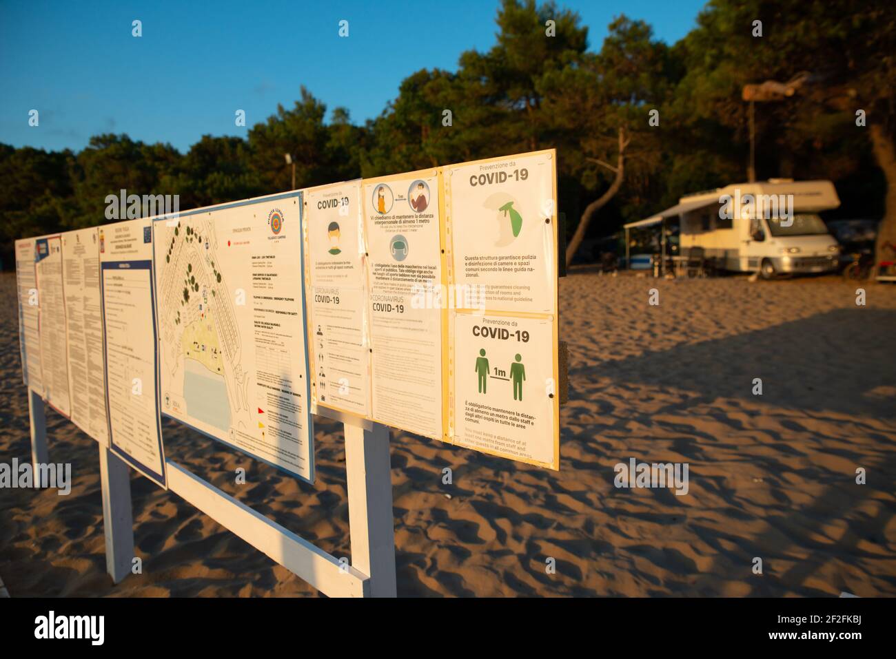 Corona Warnschild am Sandstrand - Mobilheim Hintergrund Stockfoto