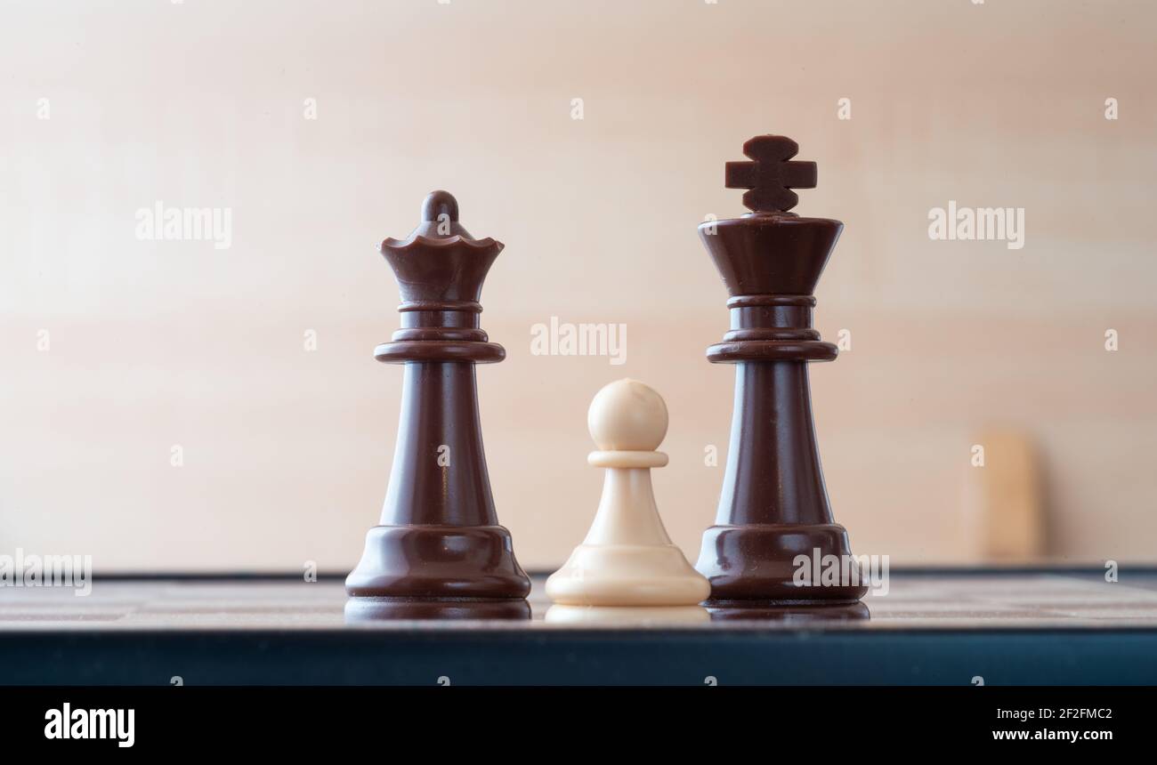 Kleine Spielfigur auf Schachbrett gegen größere Gegner Konzept der Widrigkeit, Diszimination, Gleichheit. Stockfoto
