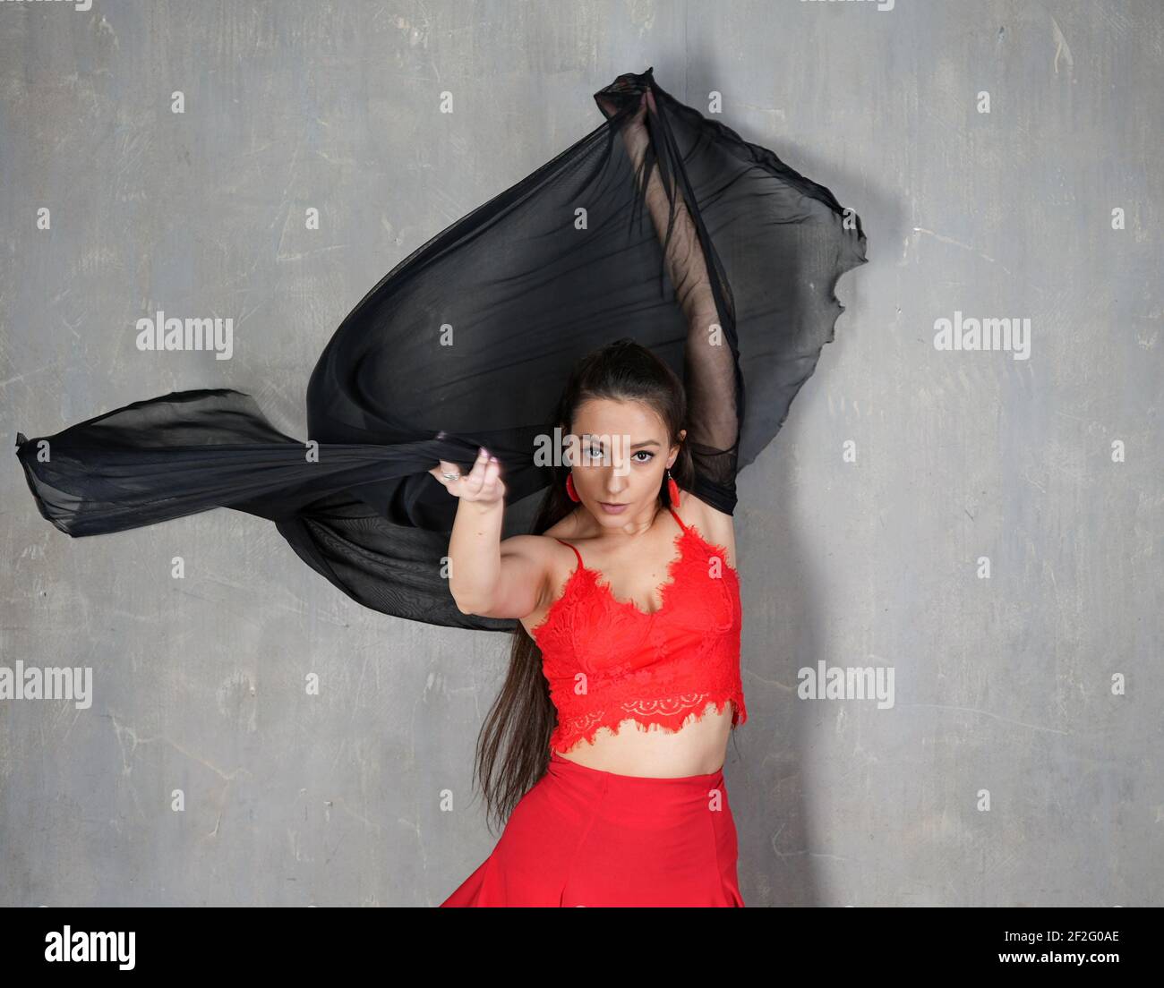 Tänzerin, Porträt in Bewegung in rotem Kleid mit einem Tuch im Wind Stockfoto