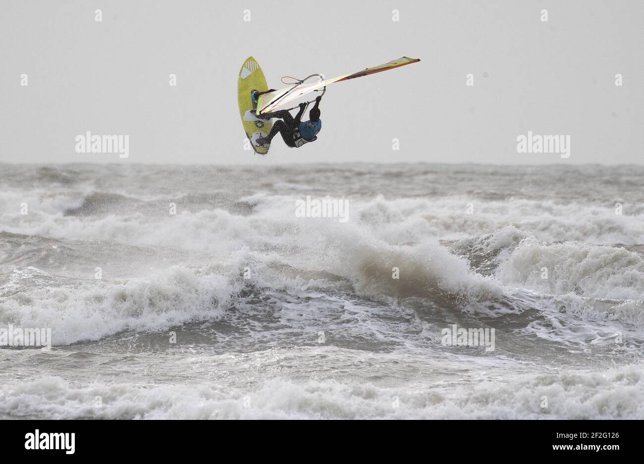Ein Windsurfer surft im rauen Meer vor dem West Wittering Strand in West Sussex. Bilddatum: Freitag, 12. März 2021. Stockfoto