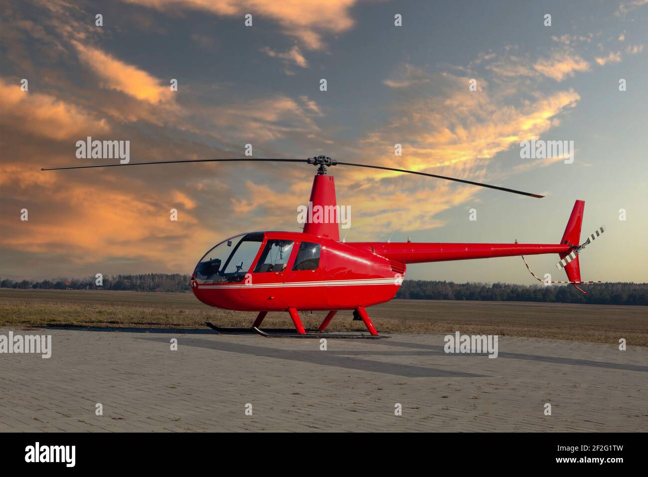 RED Helicopter Robinson R44 Raven II - Sonnenuntergang Stockfoto