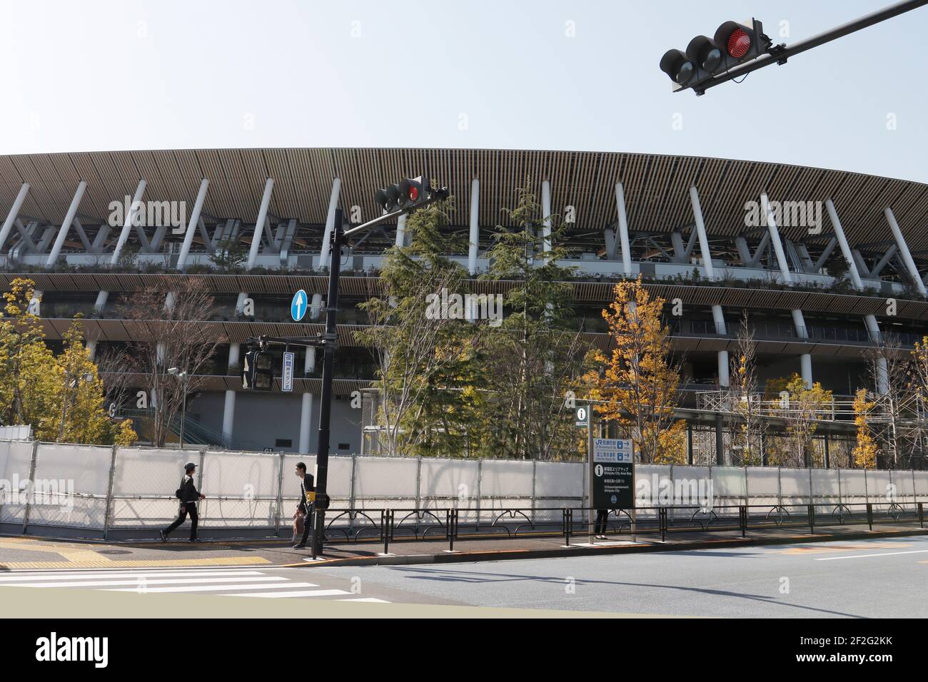 Tokio, Japan. März 2021, 12th. Eine Frau geht vor dem Nationalstadion, dem Hauptstadion der Olympischen Spiele und Paralympics 2020 in Tokio, inmitten einer Pandemie von Covid-19. Kredit: SOPA Images Limited/Alamy Live Nachrichten Stockfoto