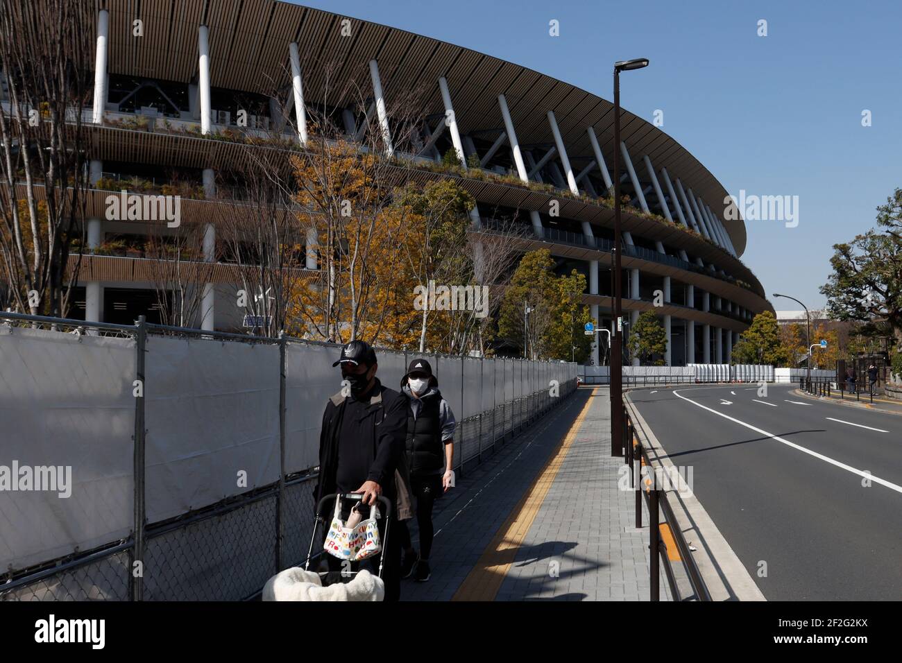 Tokio, Japan. März 2021, 12th. Ein Mann geht vor dem Nationalstadion, dem Hauptstadion der Olympischen Spiele und Paralympics 2020 in Tokio, inmitten einer Pandemie von Covid-19. Kredit: SOPA Images Limited/Alamy Live Nachrichten Stockfoto