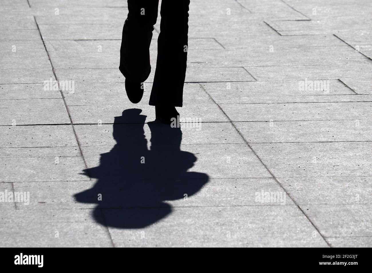 Schatten einer Frau, die auf einer Straße läuft. Konzept der Einsamkeit, Abnehmen, dramatische menschliche Leben Stockfoto Schatten einer Frau, die auf einer Straße läuft. Konzept der Einsamkeit, Abnehmen, dramatische menschliche Leben Stockfoto