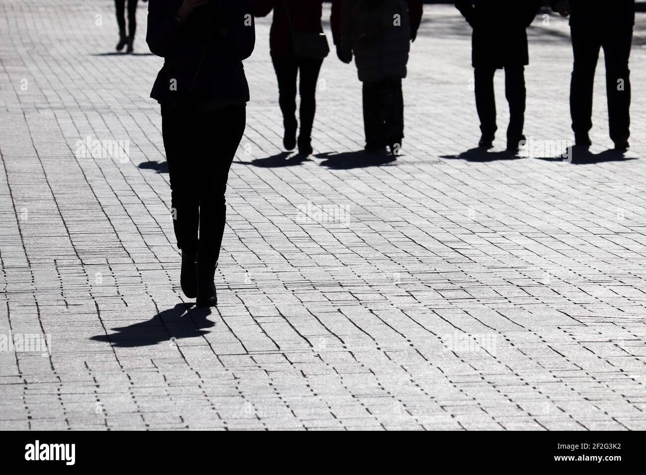 Silhouetten und Schatten von Menschen, die auf der Stadtstraße spazieren. Konzept der Gesellschaft oder Bevölkerung Stockfoto