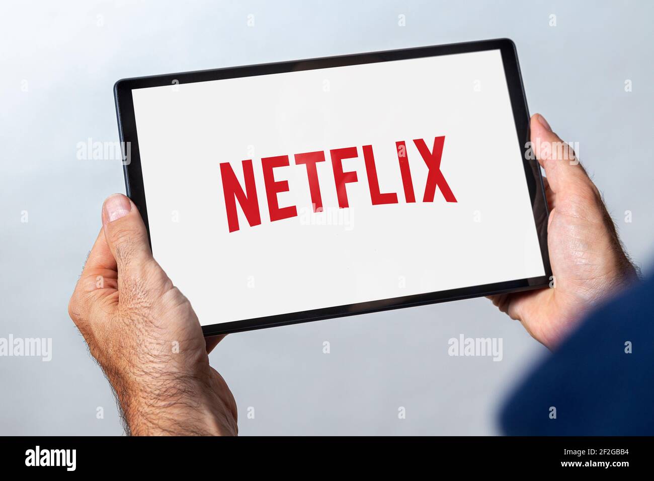 ROSARIO, ARGENTINIEN - 11. MÄRZ 2021: Mann hält ein Tablet mit netflix Video-Streaming-Service-Logo auf dem Bildschirm. Stockfoto