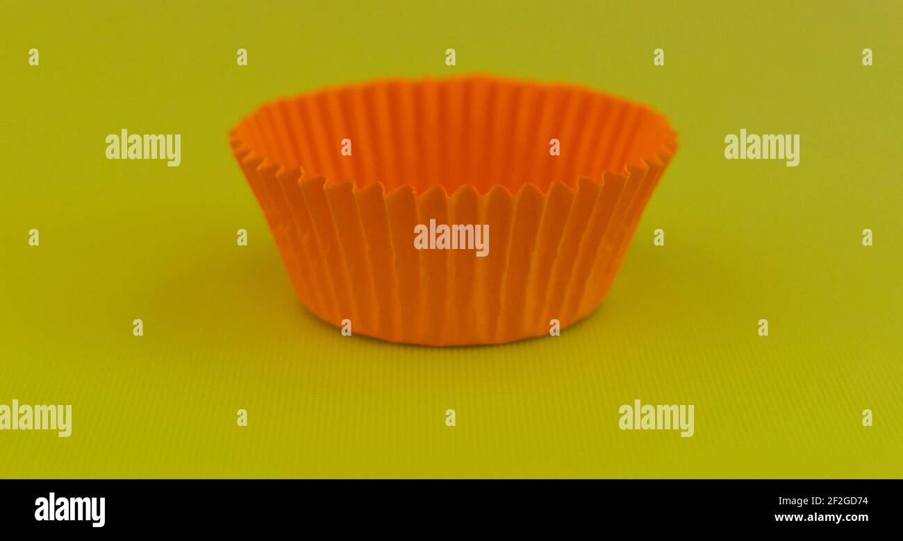 Leere orange Tasse Kuchen Fall gegen schlichten grün gelben Hintergrund Mit Kopierbereich Stockfoto