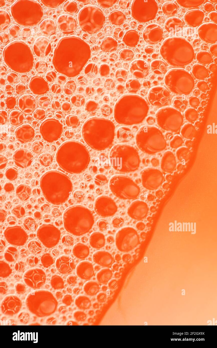 Seifenschaum Nahaufnahme auf orangefarbenem Hintergrund. Schönheit und Hygiene .Seifenschaum Hintergrund.Seifenblasen.Badeschaum Stockfoto