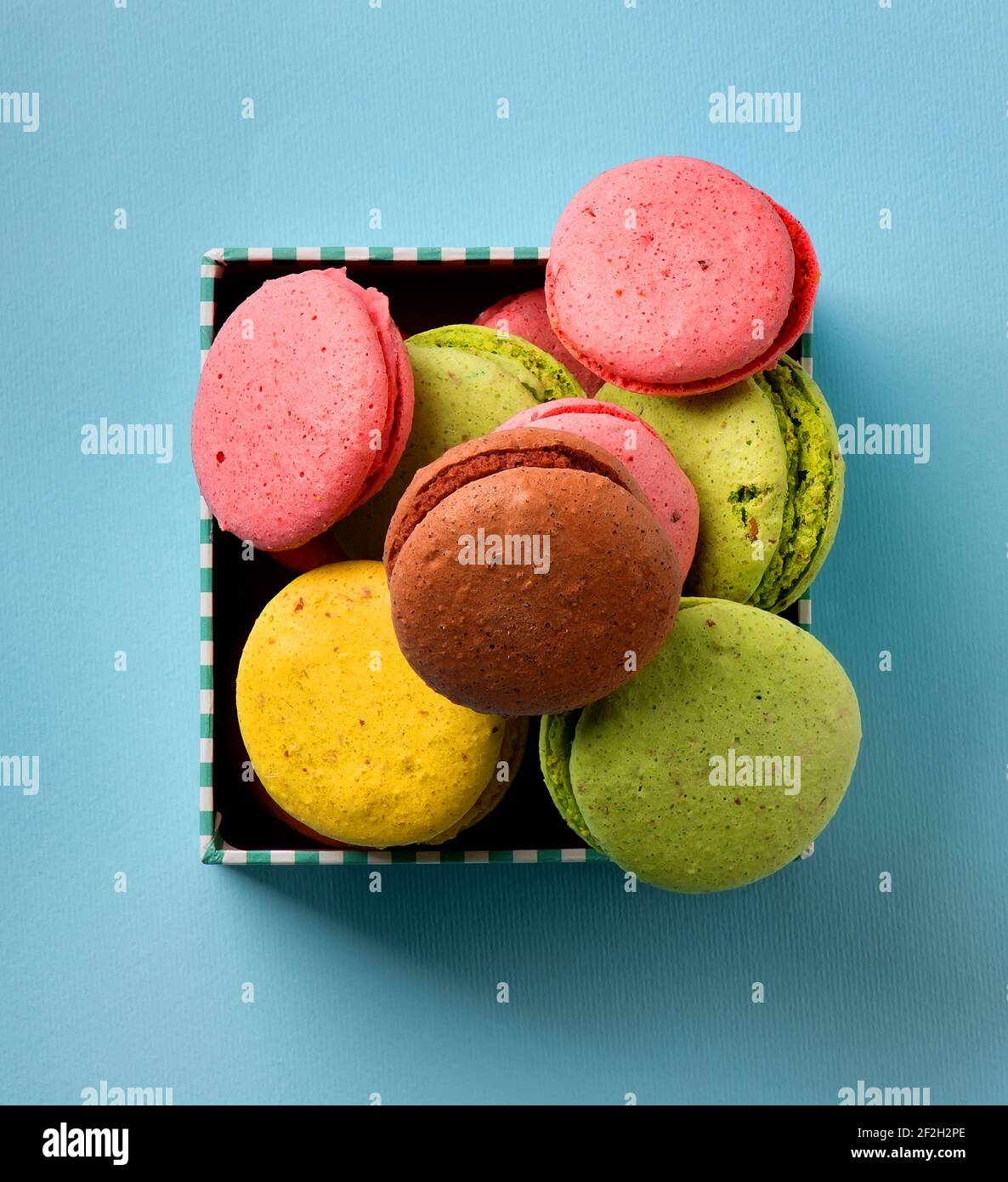 Bunte Macarons in einer Geschenkbox auf blauem Hintergrund Stockfoto
