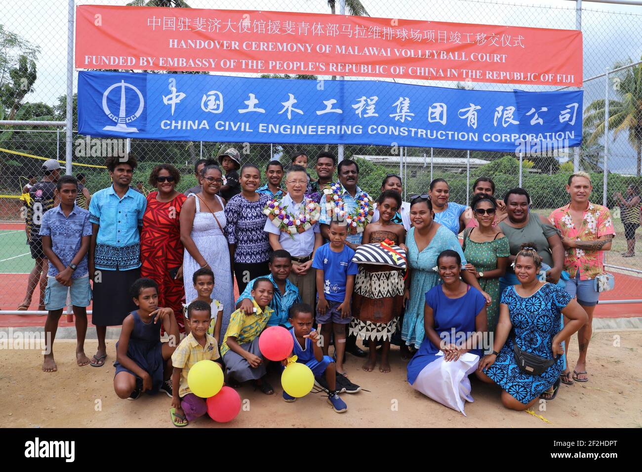 (210312) -- SUVA, 12. März 2021 (Xinhua) -- Chinesischer Botschafter in Fidschi Qian Bo (6th L, 2nd R) posiert für ein Gruppenfoto mit Fijis Minister für Jugend und Sport Parveen Kumar Bala (7th L, 2nd R) Und Anwohner bei der Übergabe eines China-Aid-Volleyballplatzes in der Malawai-Gemeinde in Nadi, Fidschi, 12. März 2021. Am Freitag wurde Fidschi in Nadi, der drittgrößten Stadt Fijis, ein Volleyballfeld übergeben, auf dem Beamte aus China und Fidschi die Sportanlage zum Wohle der lokalen Bevölkerung behuldigten. (Chinesische Botschaft in Fidschi/Handout über Xinhua) Stockfoto