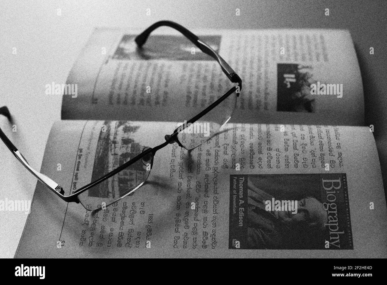 Der Leser ist müde, er hat seine Brille auf dem Buch behalten. Stockfoto