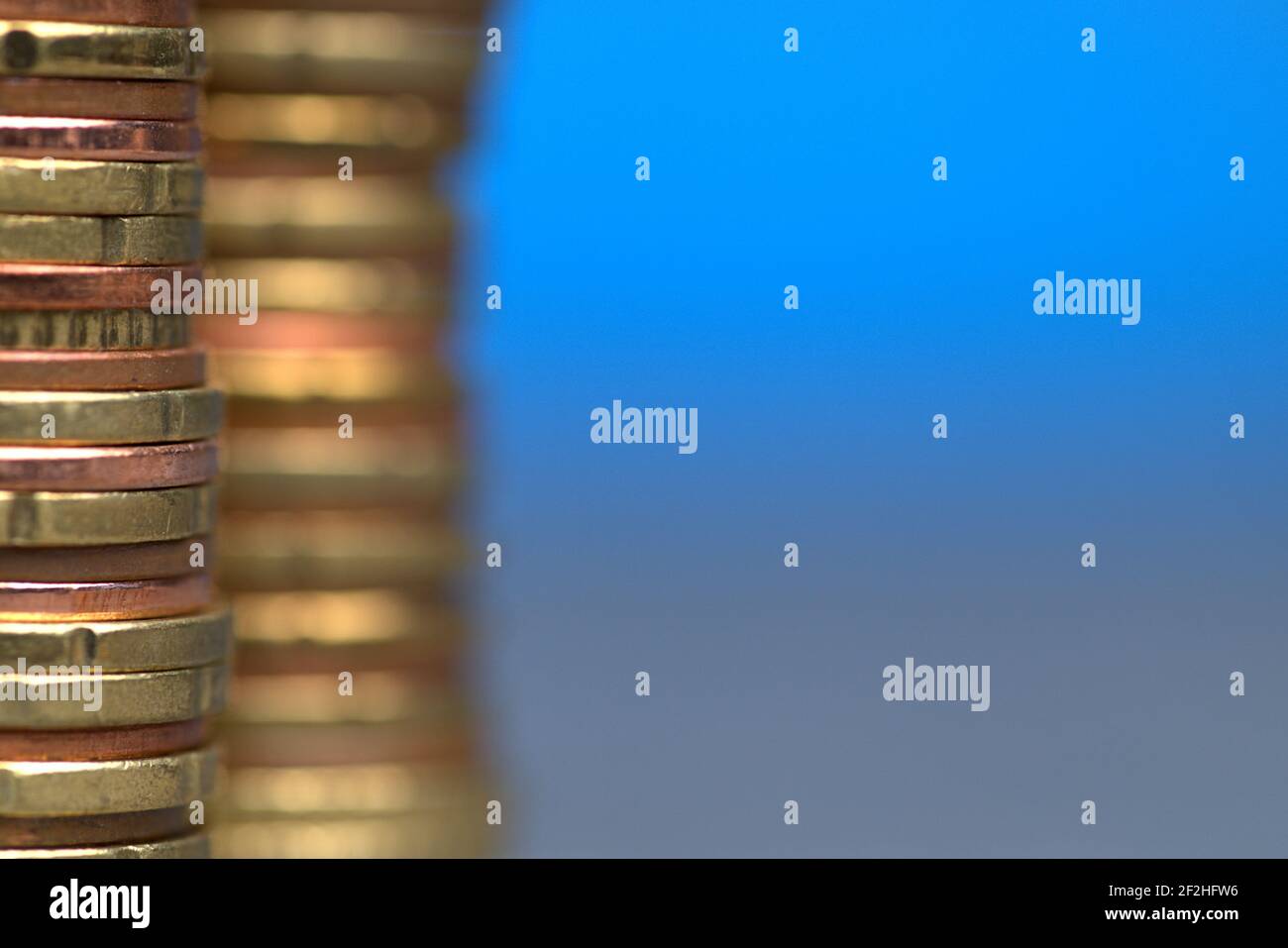 09,03.2021, zwei Stapel Euro-Cent-Münzen am linken Bildrand vor blauem Hintergrund mit einem Textfeld zur weltweiten Nutzung Stockfoto