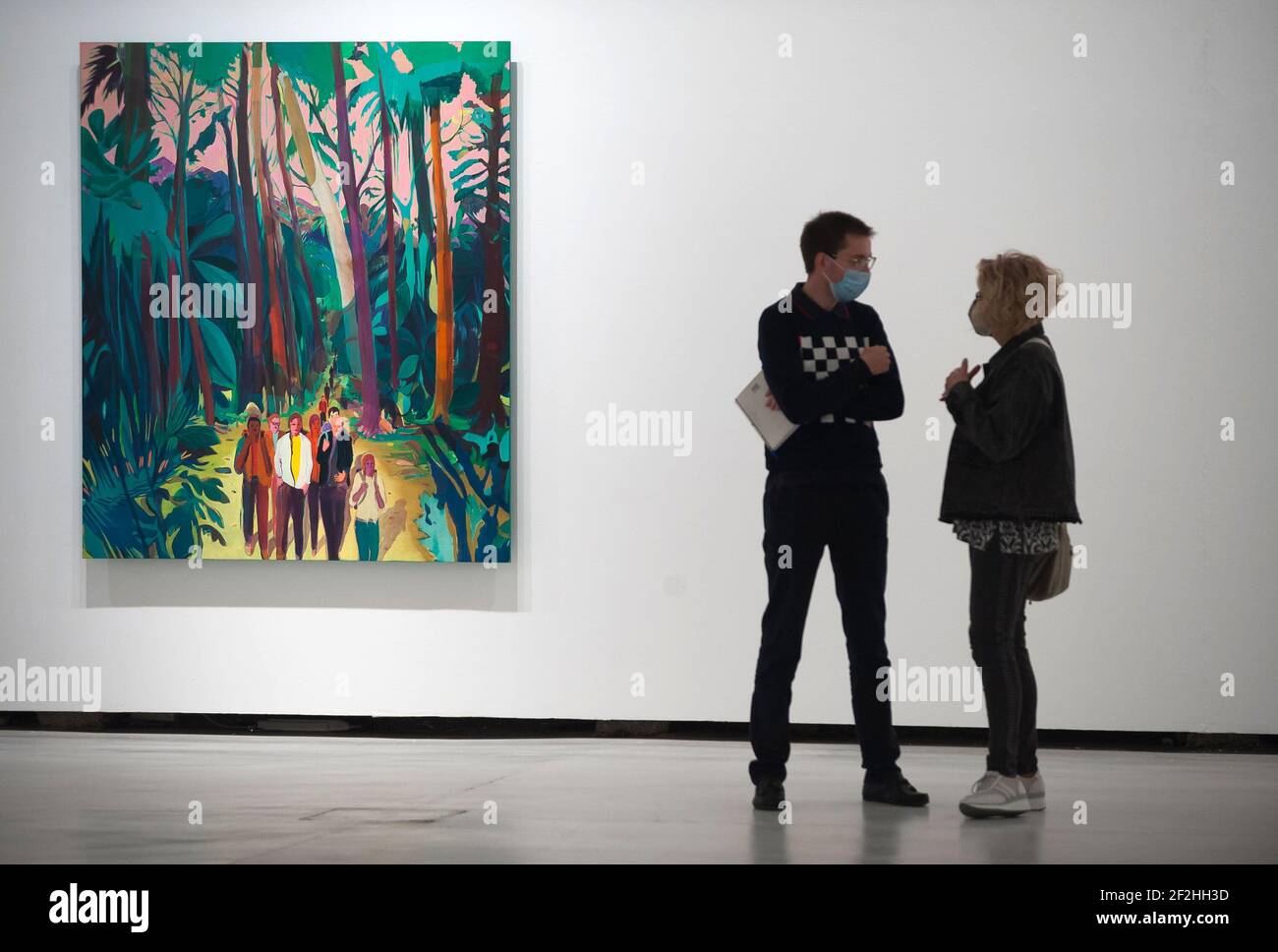 Journalisten sprechen während der Eröffnung der Ausstellung neben einem Gemälde. Nach dem Goldrausch' im Zentrum für zeitgenössische Kunst (CAC) in Malaga. Jules de Balincourt, der zum ersten Mal in Spanien ausstellt, ist ein zeitgenössischer Künstler mit Präsenz in Dutzenden von Museen, und er ist für seine abstrakten und figurativen Gemälde und die Verwendung von gesättigten Farben bekannt. Seine jüngste Ausstellung umfasst 40 Gemälde. Stockfoto