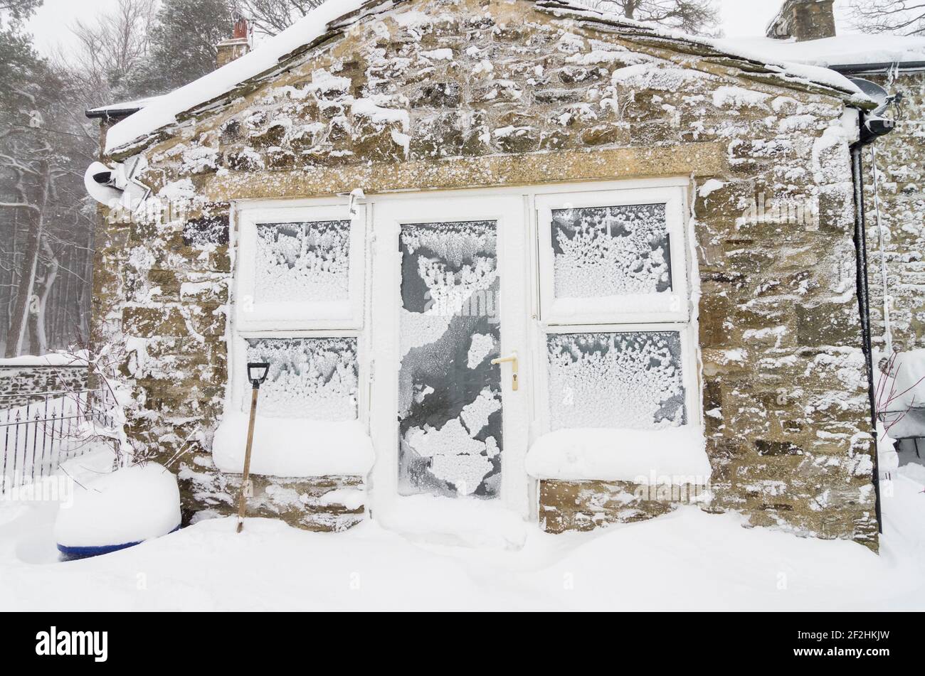 Fenster und Wände eines alten Steinhauses mit Schnee und Eis klebten an ihnen während der Beast from the East im Jahr 2018 in Weardale, North Pennines, Durham UK Stockfoto