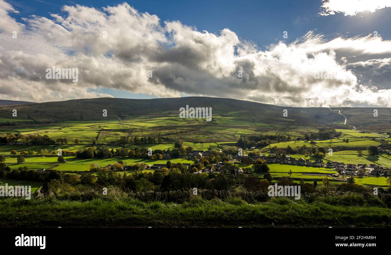 Die North Pennine Hügel in Sonnenschein und Wolke mit dem Dorf St. John's Chapel (Weardale, County Durham, UK) in der Ferne Stockfoto