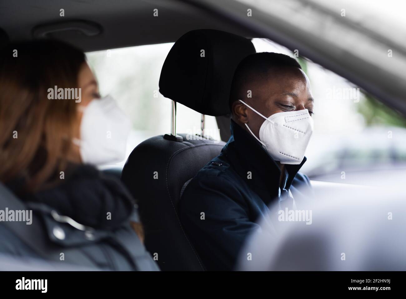 Carpool Car Ride Share Service In Gesichtsmaske Stockfoto