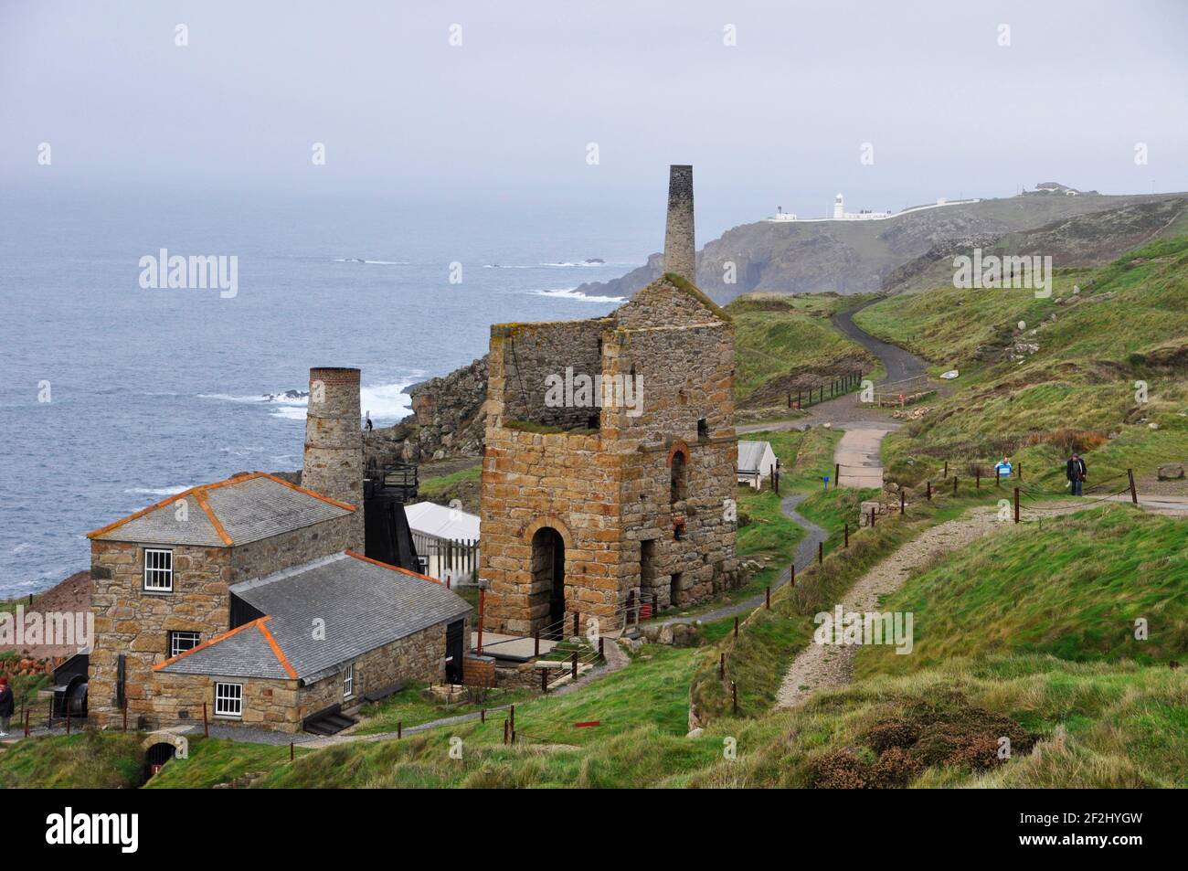 Levant Zinnmine mit seiner dampfbetriebenen Strahlmaschine auf der Klippe bei Penwith, auf der Landzunge dahinter ist der Pendeen Leuchtturm. Cornwall, England, Großbritannien Stockfoto