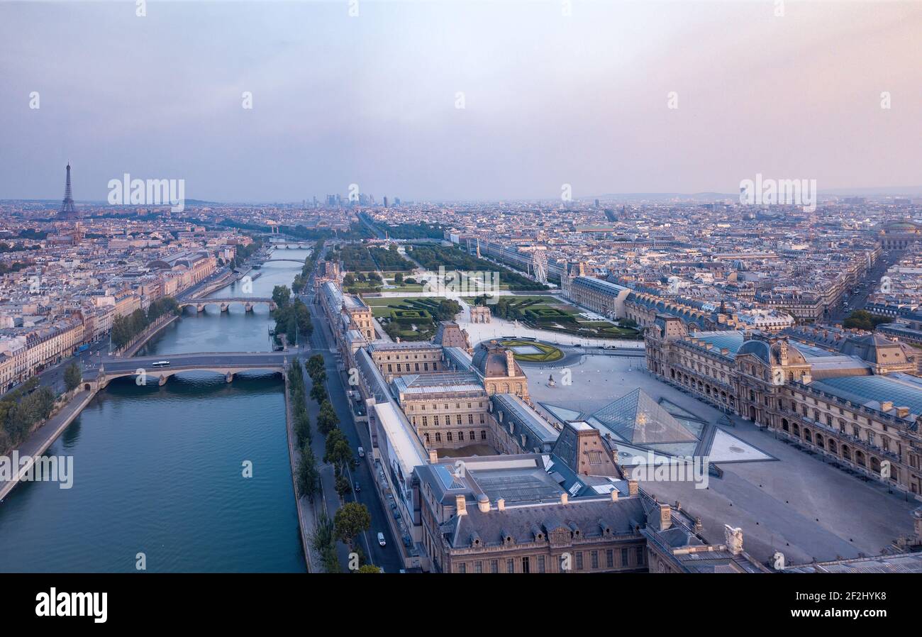 Am Morgen Luftaufnahme des Louvre-Museums am Ufer seiner mit entferntem Eiffelturm, Paris, Frankreich Stockfoto