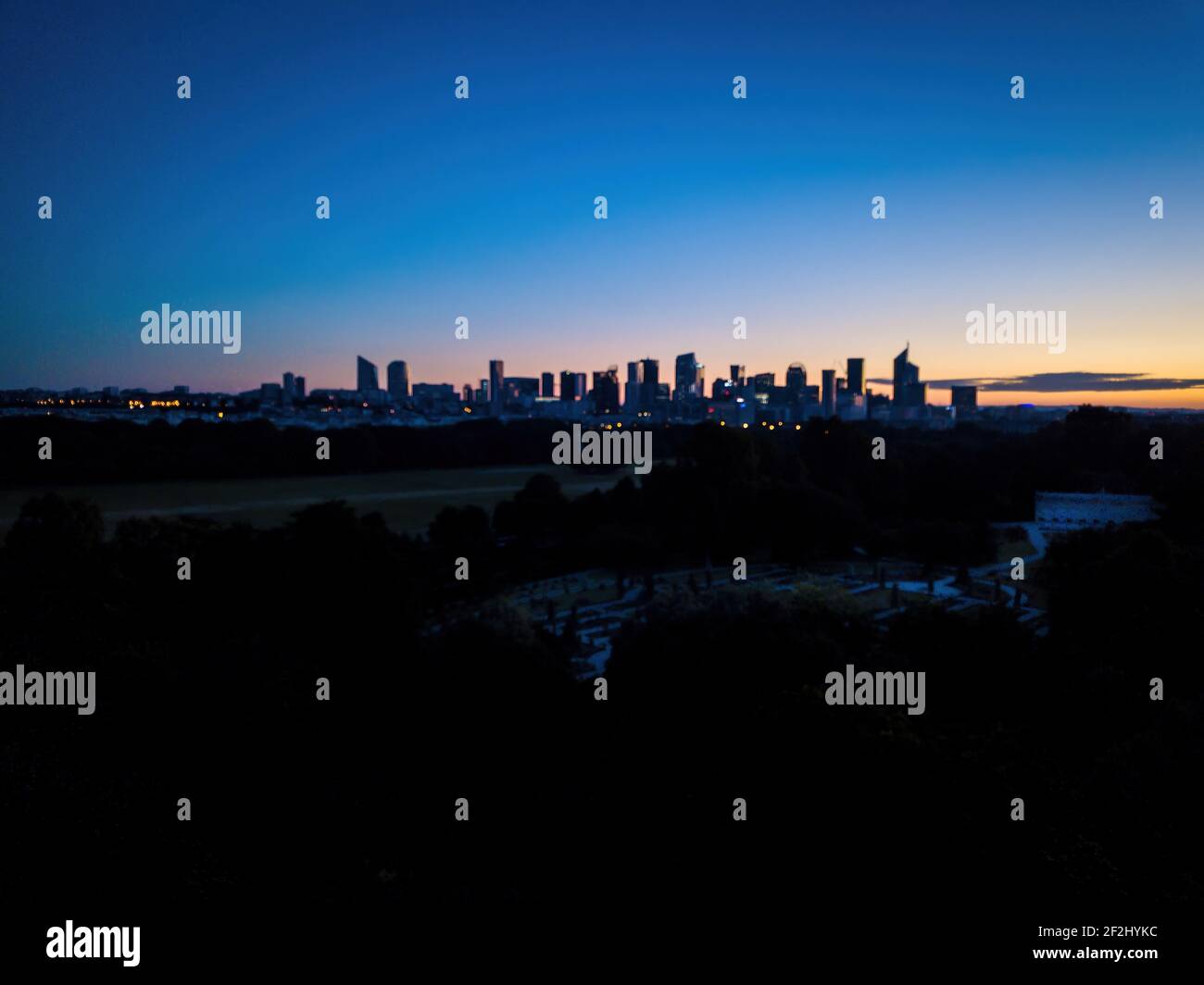 Luftaufnahme la défense von Bagatelle, mit Silhouette der Skyline von La Défense im Hintergrund am frühen Morgen Stockfoto