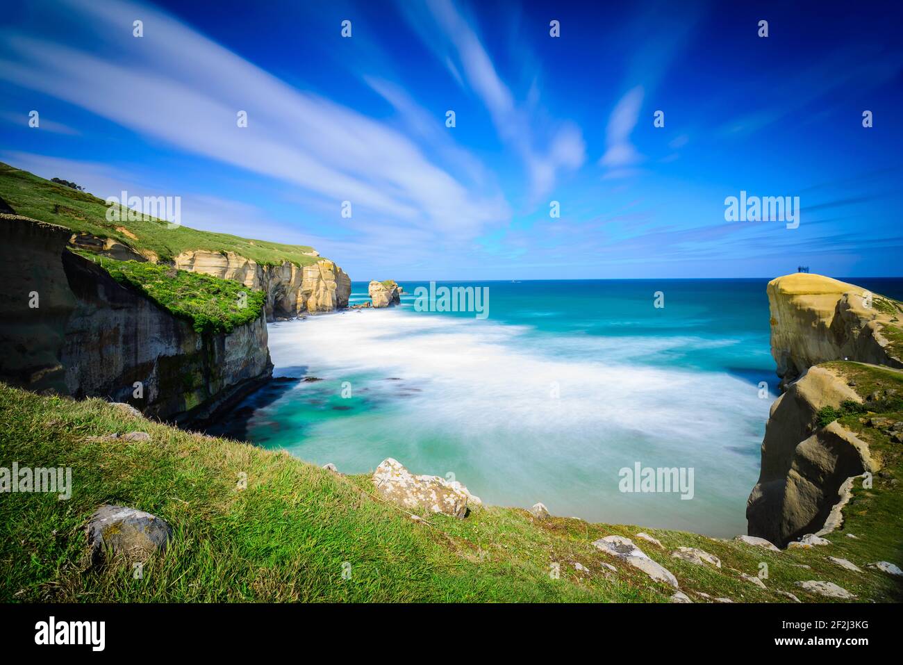 Blick auf den Tunnel-Strandweg in Dunedin, Neuseeland. Plätschernden Meereswellen waschen mächtige steile Klippen. Stockfoto