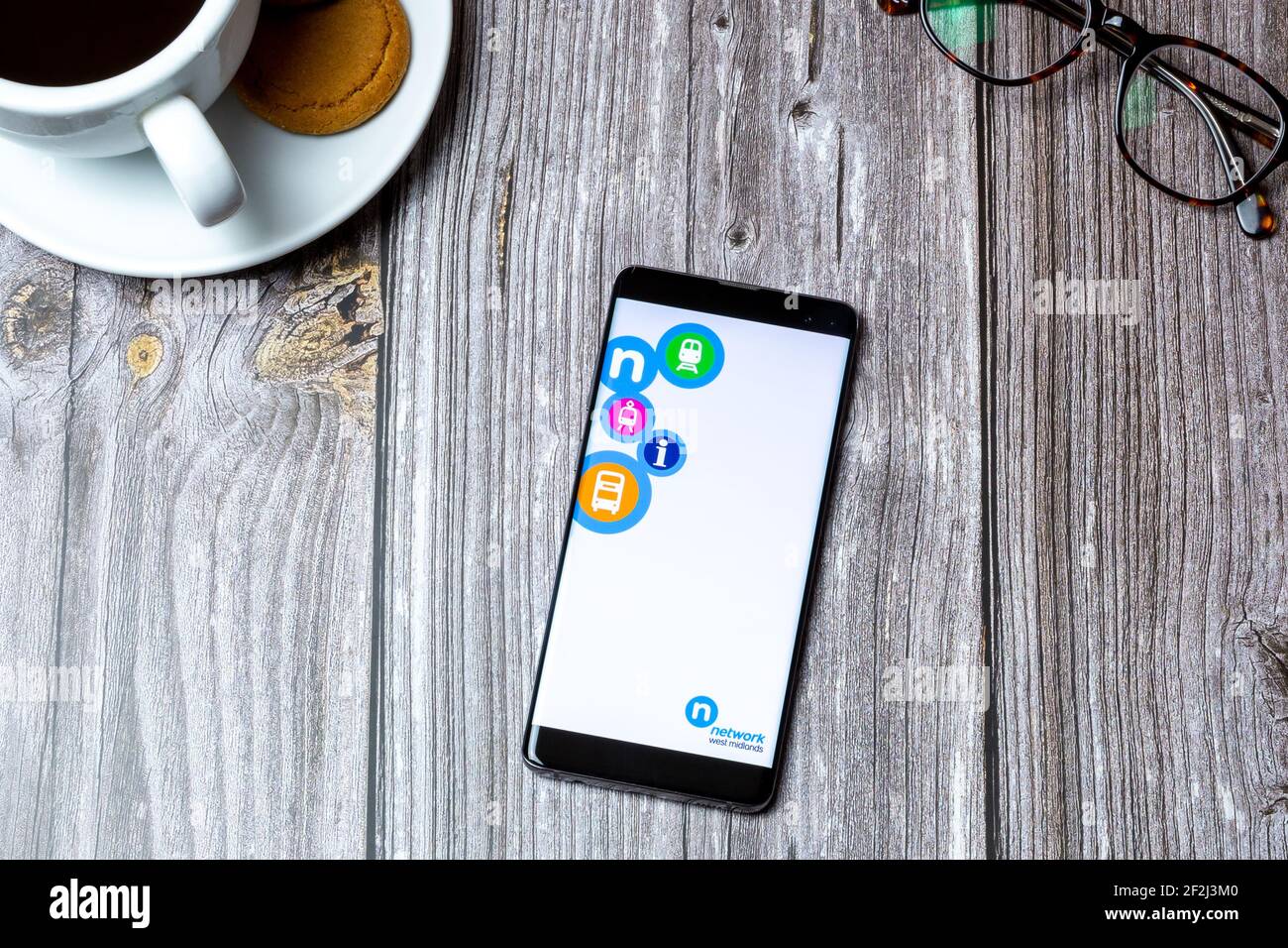 Ein Handy oder Handy auf einem Holz gelegt Tabelle mit der Network West midlands App auf dem Bildschirm geöffnet Stockfoto
