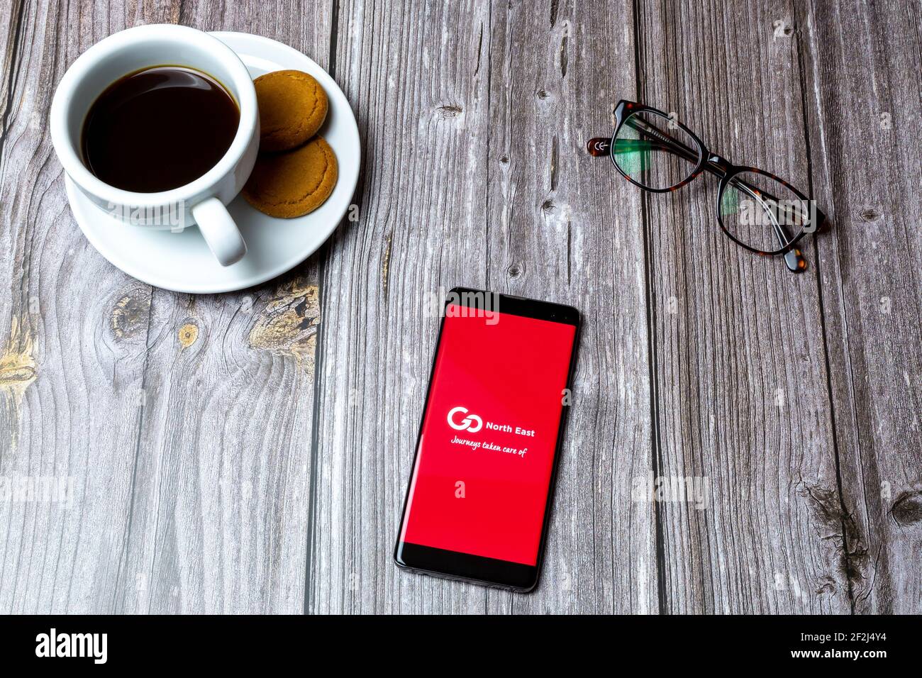 Ein Handy oder Handy auf einem Holz gelegt Tabelle mit der Go North East App auf dem Bildschirm geöffnet Stockfoto